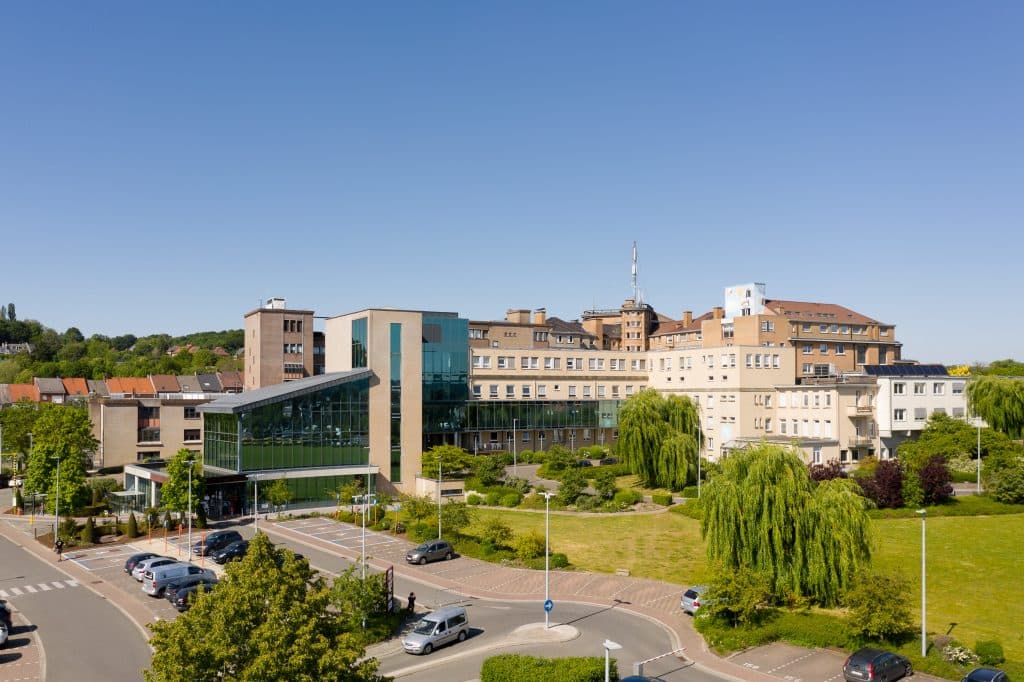 Luchtbeeld van de campus van AZ Glorieux in Ronse, met de glooiende Vlaamse Ardennen op de achtergrond